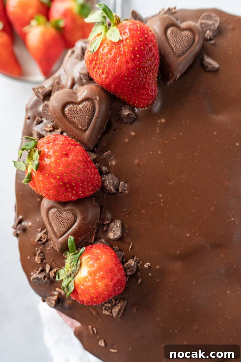 Chocolate Strawberry Layer Cake with Luscious Ganache 3 top of valentine cake with strawberries, heart candies, and crushed chocolate on top of ganache.
