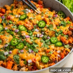 One-Pan Ground Turkey and Sweet Potato Skillet 12 Ground turkey sweet potato skillet dinner in pan with spoons scooping into the skillet.