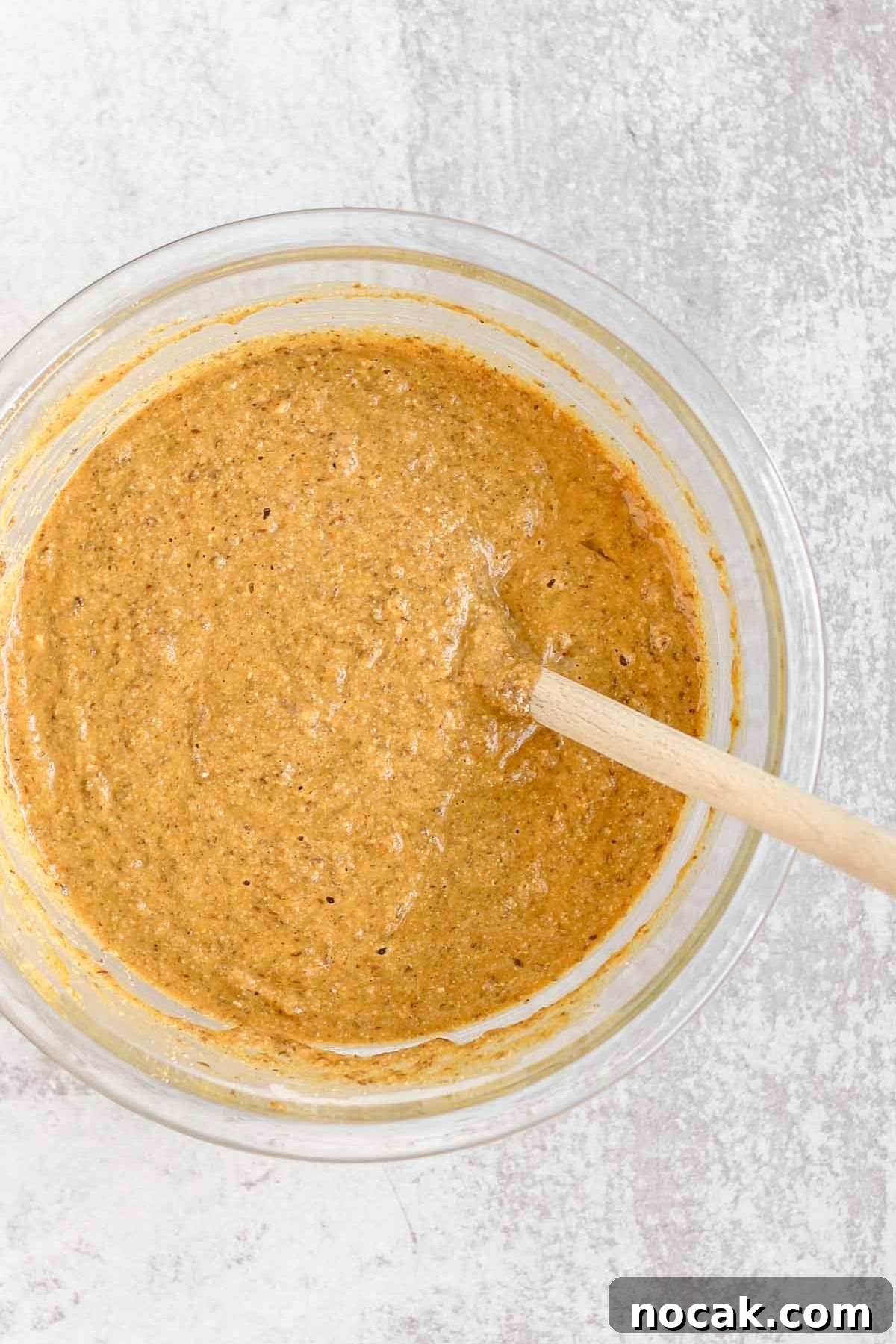 Pumpkin bread batter in a glass mixing bowl.