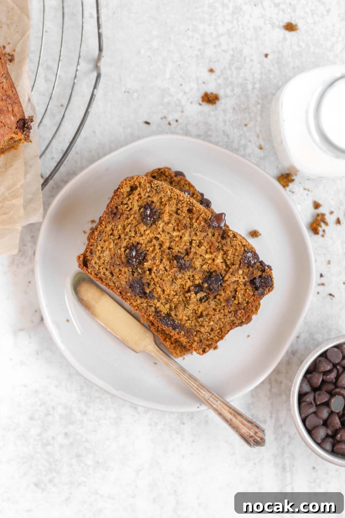 Overhead view of a piece of gluten-free pumpkin chocolate chip bread on a white plate.