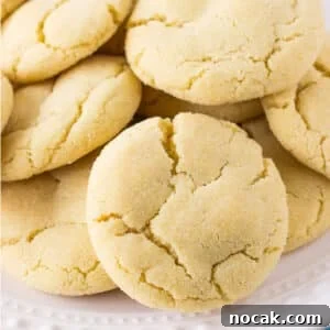 Classic Soft Sugar Cookies Recipe 7 A closeup of a pile of sugar cookies on a white plate.
