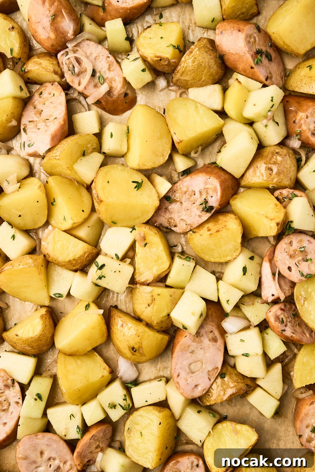 Sheet Pan Chicken Sausage with Roasted Apples 6 Chicken sausage, apples, and potatoes on a sheet pan ready to roast in the oven.