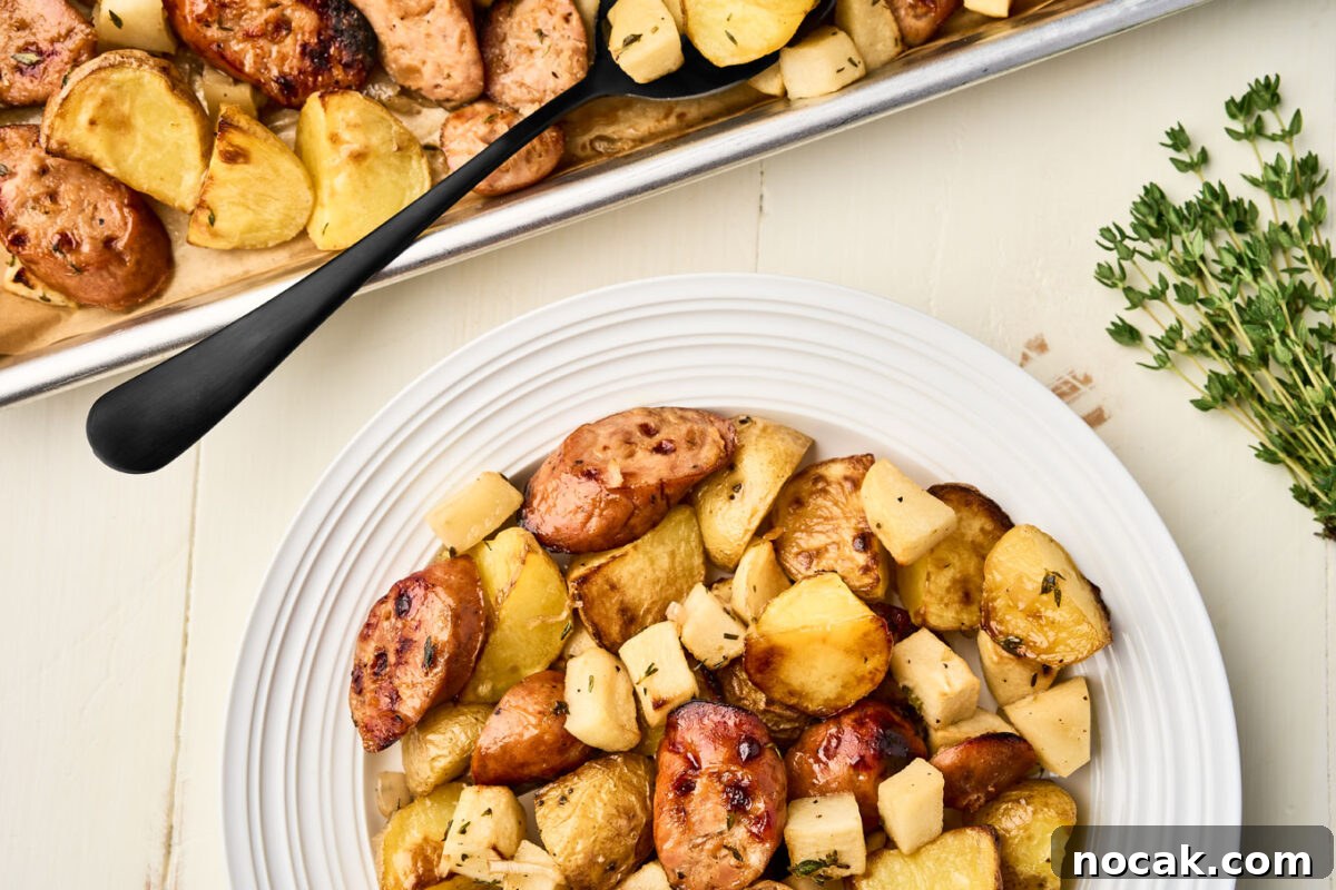 Sheet Pan Chicken Sausage with Roasted Apples 8 Overhead view of a sheet pan and plate filled with roasted chicken sausage, apples, and potatoes, an easy one-pan weeknight dinner.