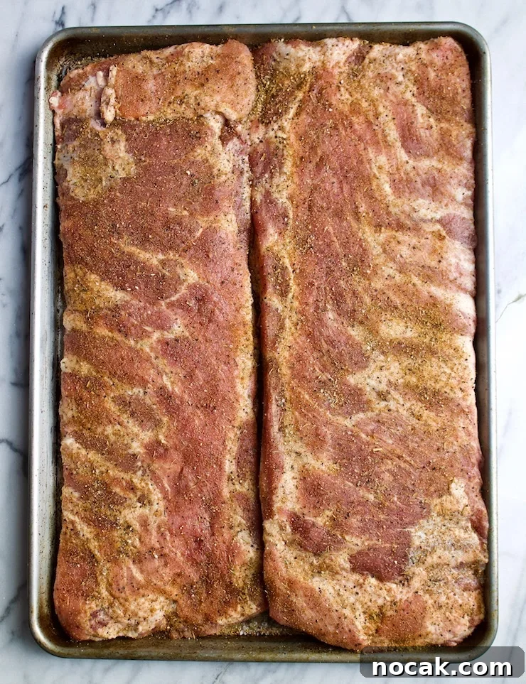 St. Louis-Style BBQ Ribs Recipe for Tender, Sticky Glaze 6 Two slabs of pork spareribs with dry rub, ready for grill.
