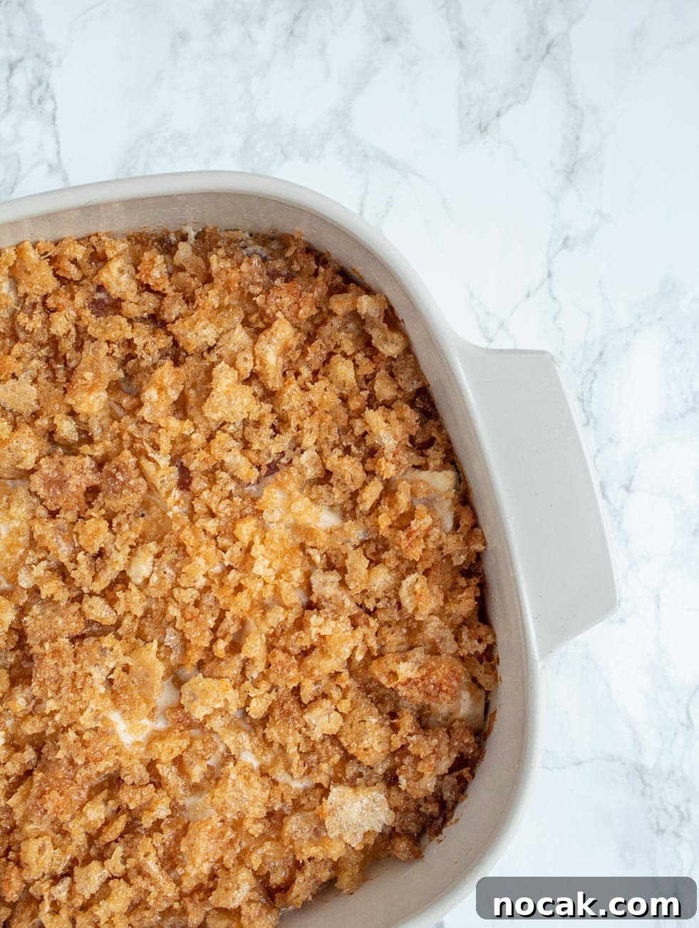 Ritzy Keto Chicken Casserole with Crispy Pork Rind Topping 2 keto casserole with pork rinds crushed on top in a white pan over a marble countertop