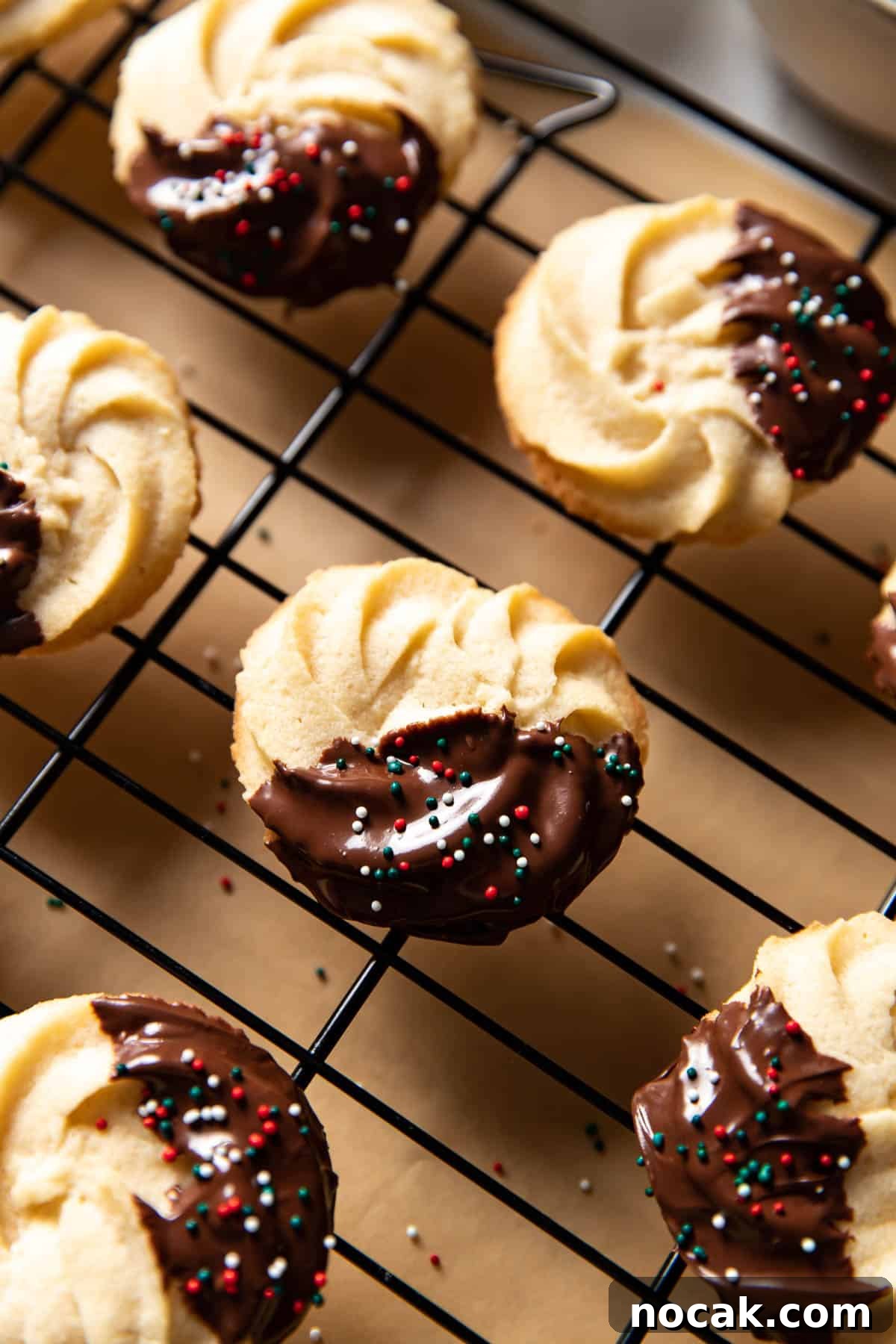 Classic Chocolate-Dipped Butter Cookies Recipe 3 chocolate dipped cookies on a cooling rack.
