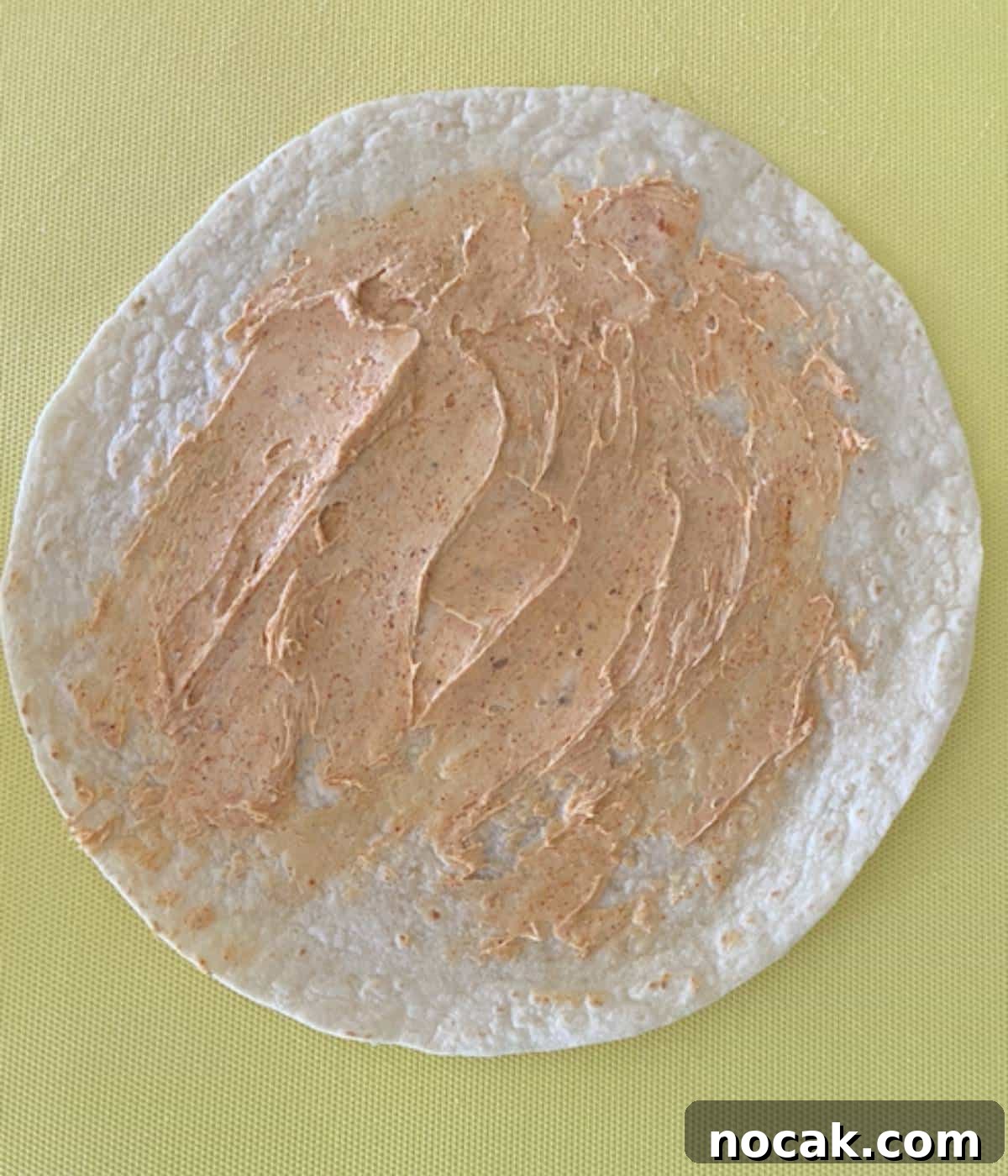 Cream cheese spread on flour tortilla.