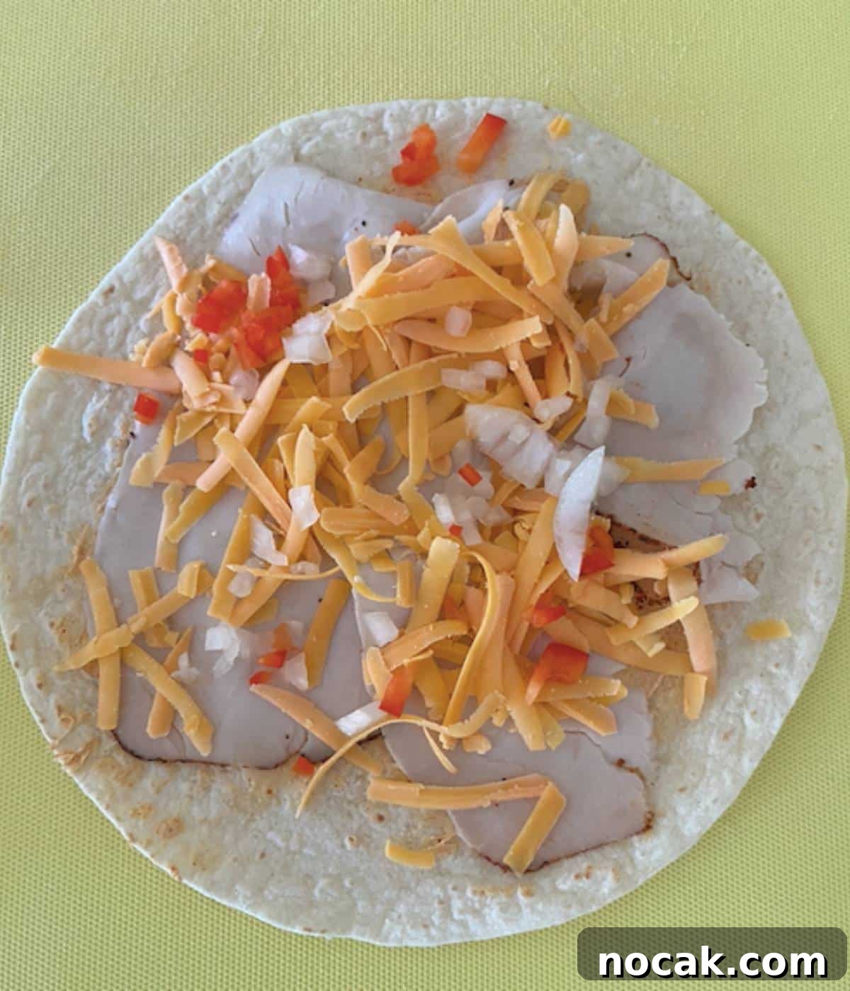 Turkey toppings on flour tortilla.